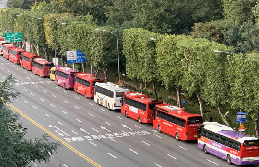 단체 참가자들이 타고 온 관광버스들이 줄 서 주차되어 있다. 이정아 기자